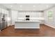Bright kitchen featuring a central island, quartz countertops, white cabinets, and stainless steel appliances at 2341 Oleander Rd, Deland, FL 32724