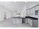 Bright kitchen boasts grey cabinets, black countertops, and an open layout into the living area at 23741 Sw Blueberry Ln, Dunnellon, FL 34431
