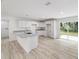 Open kitchen with white cabinets, a granite island, and sliding doors to the backyard at 23741 Sw Blueberry Ln, Dunnellon, FL 34431