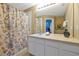 Well-lit bathroom features a shower with curtain, large vanity, and ample storage space in a rental home at 2546 Maneshaw Ln, Kissimmee, FL 34747