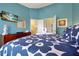 Bright bedroom features a large blue flower patterned bedspread and television in a cozy vacation home at 2546 Maneshaw Ln, Kissimmee, FL 34747