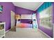 Fun bunk beds sit against purple walls in this bright and cheerful bedroom in this vacation rental at 2546 Maneshaw Ln, Kissimmee, FL 34747