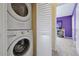 Convenient laundry room with washer and dryer, located next to a cheerful purple bedroom in a vacation home at 2546 Maneshaw Ln, Kissimmee, FL 34747