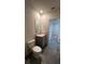 View of bathroom with gray tiled floor, toilet and single sink vanity at 2597 Shamrock St, Tavares, FL 32778