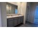 Bathroom boasting a double vanity with gray cabinets and a full mirror at 2597 Shamrock St, Tavares, FL 32778