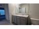 Bathroom featuring a double vanity with gray cabinets and a toilet at 2597 Shamrock St, Tavares, FL 32778