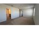 Large bedroom with neutral walls, carpeted floor, and entry to a bathroom at 2597 Shamrock St, Tavares, FL 32778