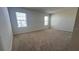 A simple bedroom with neutral carpet and natural light from two windows at 2597 Shamrock St, Tavares, FL 32778