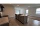 Kitchen island with a stainless steel sink, dishwasher, and gray cabinets at 2597 Shamrock St, Tavares, FL 32778