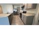 Kitchen with tile flooring and gray cabinetry including a stainless steel oven, dishwasher, and refrigerator at 2597 Shamrock St, Tavares, FL 32778