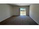 A carpeted, bright, living room with sliding glass doors at 2597 Shamrock St, Tavares, FL 32778