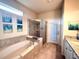 Elegant bathroom featuring a soaking tub, tiled shower, and a vanity with granite countertops at 3044 Mahalo Dr, Davenport, FL 33897