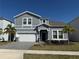 Charming two-story home with a well-maintained lawn, an attached garage, and beautiful exterior paint at 3044 Mahalo Dr, Davenport, FL 33897