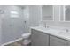 Modern bathroom showcasing double sinks, quartz countertops, and tiled walk-in shower at 323 Shadow Oak Dr, Casselberry, FL 32707