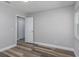 Light gray bedroom with wood-look flooring and open closet at 323 Shadow Oak Dr, Casselberry, FL 32707