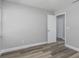 Bright bedroom with light gray walls and wood-look flooring and view to another bedroom at 323 Shadow Oak Dr, Casselberry, FL 32707