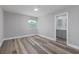 Well-lit bedroom features wood-look floors, a neutral color scheme and bathroom access at 323 Shadow Oak Dr, Casselberry, FL 32707