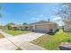 Inviting single-story home featuring a well-maintained lawn and a paved driveway leading to an attached two-car garage at 323 Shadow Oak Dr, Casselberry, FL 32707