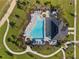 Stunning aerial view of the community pool, surrounded by lush landscaping and lounge chairs at 4418 Lions Gate Ave, Clermont, FL 34711