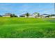 A serene backyard view showcases a green lawn, complemented by neighboring homes in the distance at 4418 Lions Gate Ave, Clermont, FL 34711