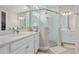 Modern bathroom featuring double vanity, frameless shower, white cabinets, and stylish tile floors at 4418 Lions Gate Ave, Clermont, FL 34711