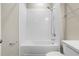 A bathtub with white tiling, shower, and quartz counter at 4418 Lions Gate Ave, Clermont, FL 34711