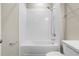 Bathroom features a shower and bathtub combination with sleek white tile and modern fixtures at 4418 Lions Gate Ave, Clermont, FL 34711