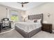 A relaxing bedroom showcasing a tufted headboard, plush bedding, and a dedicated workspace near the window at 4418 Lions Gate Ave, Clermont, FL 34711