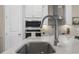 Close up of a stylish kitchen island and sink with stainless steel appliances and grey backsplash at 4418 Lions Gate Ave, Clermont, FL 34711