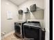 Laundry room featuring modern, stainless steel washer and dryer, storage shelves, and wood-look vinyl floors at 4418 Lions Gate Ave, Clermont, FL 34711