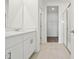 Bright bathroom with dual vanities, white cabinets, walk-in shower, and a walk-in closet at 4544 Windy Oak Way, St Cloud, FL 34772