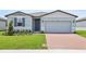 Charming single-story home with a well-manicured lawn and brick driveway leading to a two-car garage at 4544 Windy Oak Way, St Cloud, FL 34772