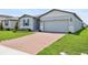 Well-maintained single-story home with brick driveway, two-car garage, and green lawn at 4544 Windy Oak Way, St Cloud, FL 34772