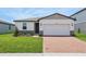 Charming home featuring a brick driveway, two-car garage, and manicured lawn at 4550 Windy Oak Way, St Cloud, FL 34772