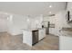 Open kitchen with a central island, stainless steel dishwasher, and white cabinets at 4550 Windy Oak Way, St Cloud, FL 34772