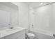 Modern bathroom featuring white fixtures, shower-tub combination, and tiled walls at 4556 Windy Oak Way, St Cloud, FL 34772