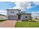 Two-story home with a brick driveway, lawn, and a mix of siding and stucco exterior at 4556 Windy Oak Way, St Cloud, FL 34772
