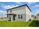 Rear exterior of home featuring a walkout covered porch and well-manicured lawn at 4556 Windy Oak Way, St Cloud, FL 34772