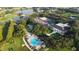 Aerial view of the community clubhouse, pool, tennis courts, and surrounding golf course and ponds at 4638 Destrehan, Leesburg, FL 34748