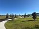 Scenic park with grassy fields, walking path, playground, picnic tables, and trees on a clear sunny day at 5059 Lake Hamlin Trl, Winter Garden, FL 34787