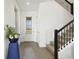 Bright, tiled foyer featuring a stairway with black metal railing and a view of the front door at 5059 Lake Hamlin Trl, Winter Garden, FL 34787