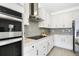 Modern kitchen featuring white cabinetry, granite countertops, stainless steel appliances, and stylish backsplash at 5059 Lake Hamlin Trl, Winter Garden, FL 34787