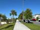 Long sidewalk along a neighborhood street lined with palm trees and parked cars at 5059 Lake Hamlin Trl, Winter Garden, FL 34787