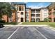 A condominium building boasting multiple stories, neutral-colored exteriors, balconies, and manicured lawn at 5512 Metrowest Blvd # 203, Orlando, FL 32811