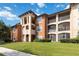 Exterior view of a condo complex with multiple stories, neutral paint, balconies, and well-maintained landscaping at 5512 Metrowest Blvd # 203, Orlando, FL 32811