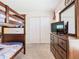 Nautical-themed bedroom featuring a wooden bunk bed, dresser with television, and closet for storage at 5528 Solterra Cir, Davenport, FL 33837