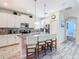 Well-lit kitchen with breakfast bar seating, modern appliances, and tiled floors at 5528 Solterra Cir, Davenport, FL 33837