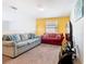 Cozy living room featuring ample seating, a colorful accent wall, and a large television for entertainment at 5528 Solterra Cir, Davenport, FL 33837