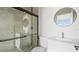 Modern bathroom with glass shower door, sleek fixtures, and a round mirror above a stylish sink at 6084 Sw 150Th Ln, Ocala, FL 34473