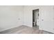 Bedroom featuring wood-look floors, and an ensuite bathroom with modern glass shower visible through open doorway at 6084 Sw 150Th Ln, Ocala, FL 34473